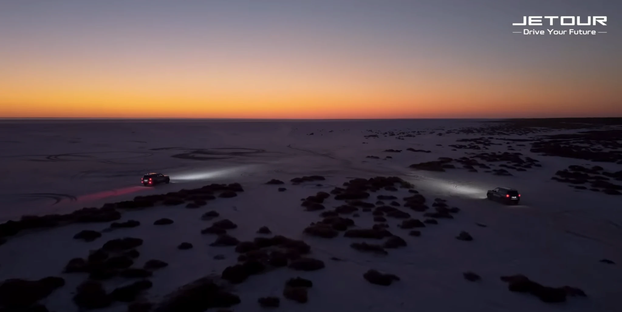 A vehicle convoy at sunset in the JETOUR film